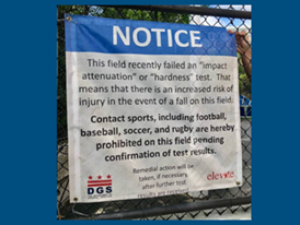 Sign on artificial turf field stating that the field failed an "impact attenuation" or "hardness" test, which means that there is an increased risk of injury in the event of a fall.